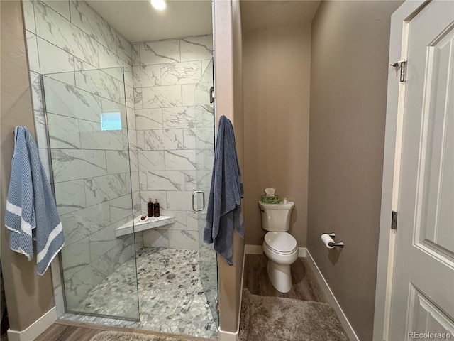 bathroom with toilet, hardwood / wood-style floors, and walk in shower