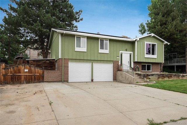 11805 W 74th Ave, Arvada, CO 80005 - raised ranch featuring an attached garage, driveway, board and batten siding, and brick siding