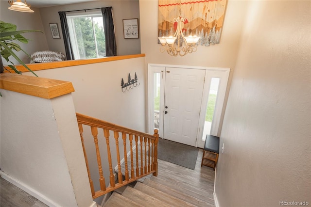 11805 W 74th Ave, Arvada, CO 80005 - entryway featuring wood finished floors, a chandelier, and stairs