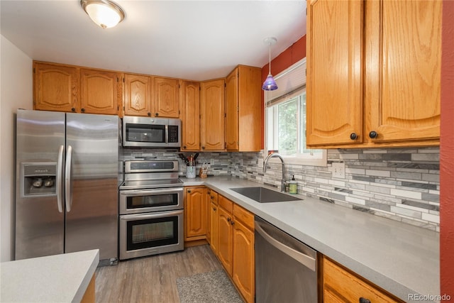 11805 W 74th Ave, Arvada, CO 80005 - kitchen featuring appliances with stainless steel finishes, light countertops, backsplash, and light wood-type flooring