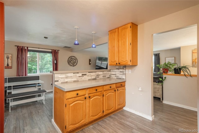11805 W 74th Ave, Arvada, CO 80005 - kitchen featuring a peninsula, light wood-type flooring, tasteful backsplash, and light countertops