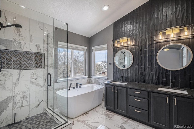 bathroom featuring lofted ceiling, tile walls, marble finish floor, and a sink