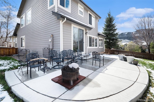 snow covered patio featuring fence and a mountain view