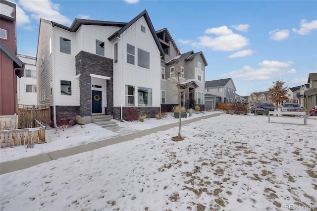 view of front of property with stone siding, a residential view, and board and batten siding