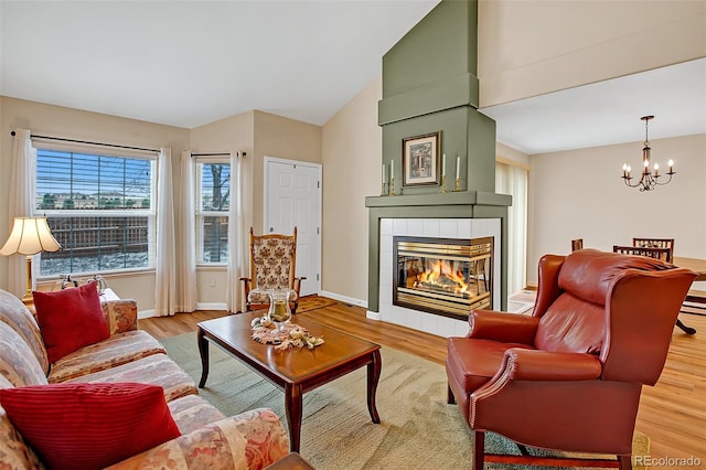 living room featuring light hardwood / wood-style floors, an inviting chandelier, and lofted ceiling