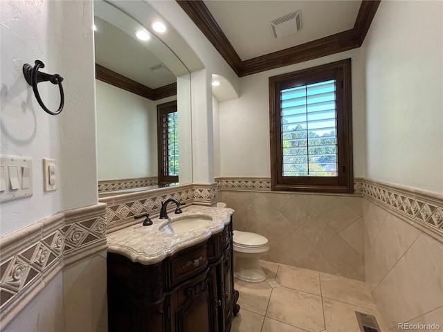 bathroom with vanity, ornamental molding, tile walls, and toilet