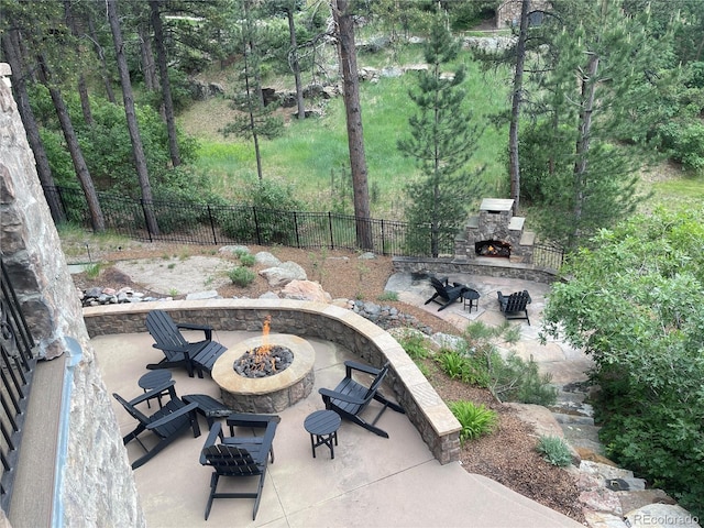 view of patio / terrace with an outdoor stone fireplace and an outdoor fire pit