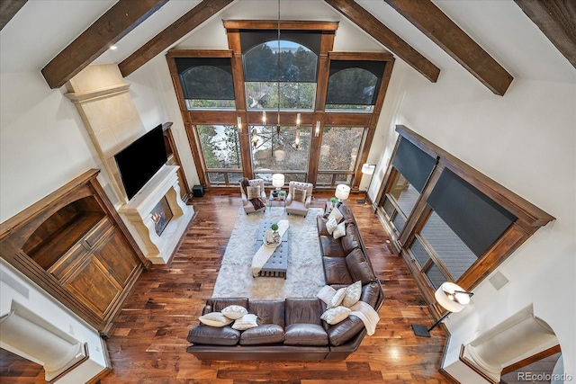 living room with dark hardwood / wood-style flooring, high vaulted ceiling, and plenty of natural light