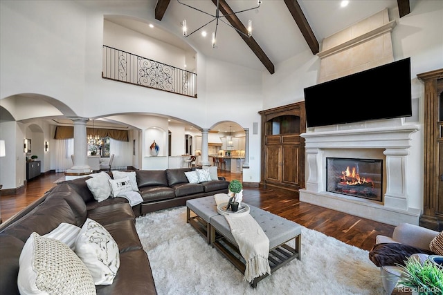 living room with wood-type flooring, beamed ceiling, a chandelier, and high vaulted ceiling