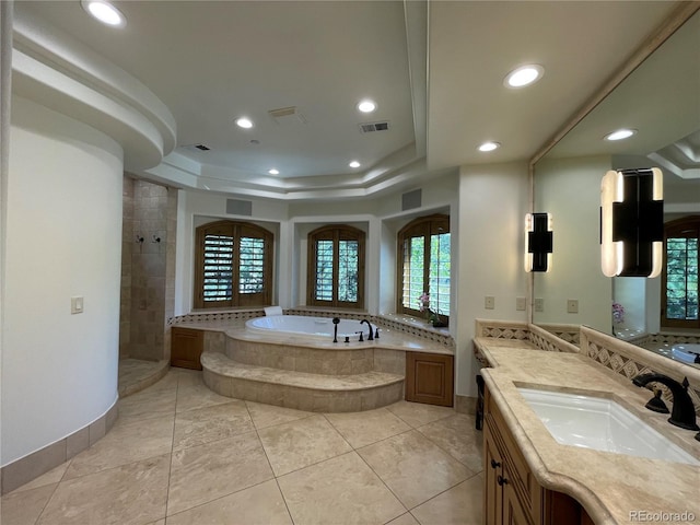 bathroom with tile patterned floors, vanity, shower with separate bathtub, and a tray ceiling