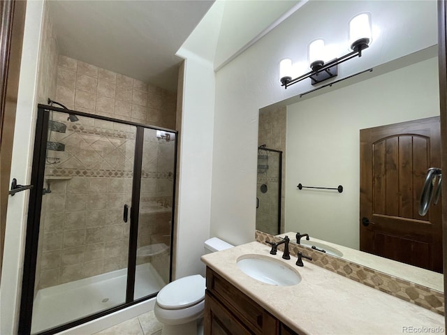 bathroom featuring vanity, a shower with door, tile patterned flooring, and toilet