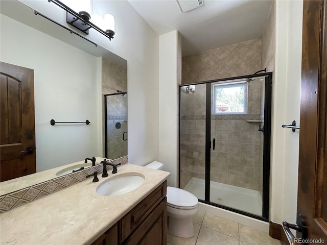 bathroom with toilet, tile patterned flooring, vanity, and walk in shower