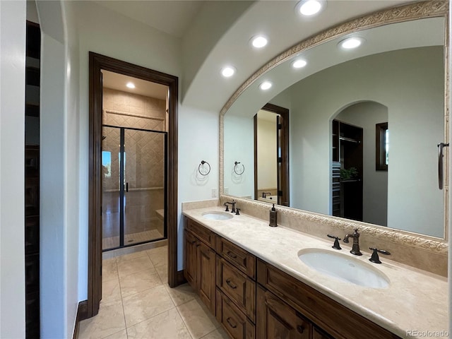 bathroom with tile patterned flooring, vanity, and a shower with door