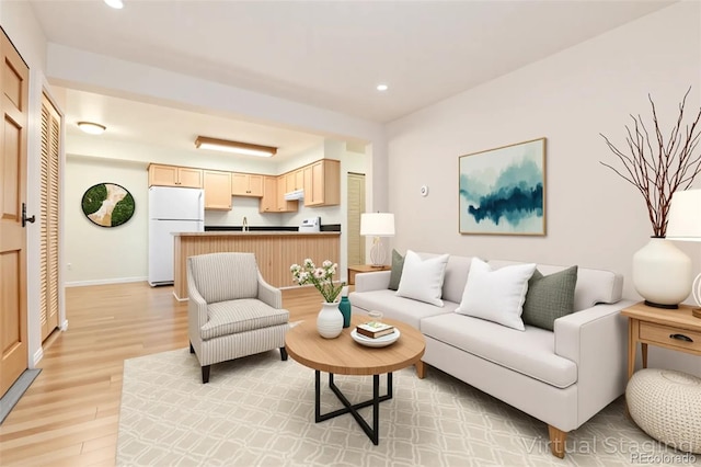 living room with light wood-style floors, recessed lighting, and baseboards