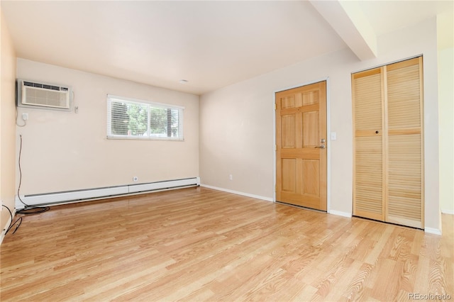 unfurnished bedroom featuring baseboards, light wood-style flooring, and baseboard heating