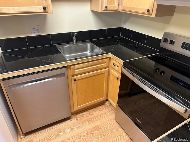 kitchen with light brown cabinetry, tile countertops, appliances with stainless steel finishes, and a sink