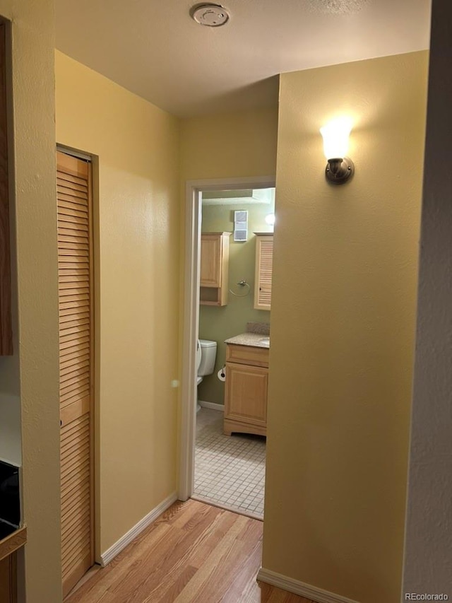 hall featuring baseboards and light wood-type flooring