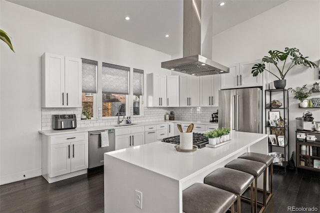 kitchen featuring sink, white cabinetry, stainless steel appliances, a center island, and island exhaust hood