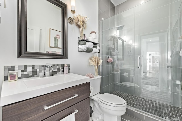 bathroom with decorative backsplash, walk in shower, vanity, and toilet