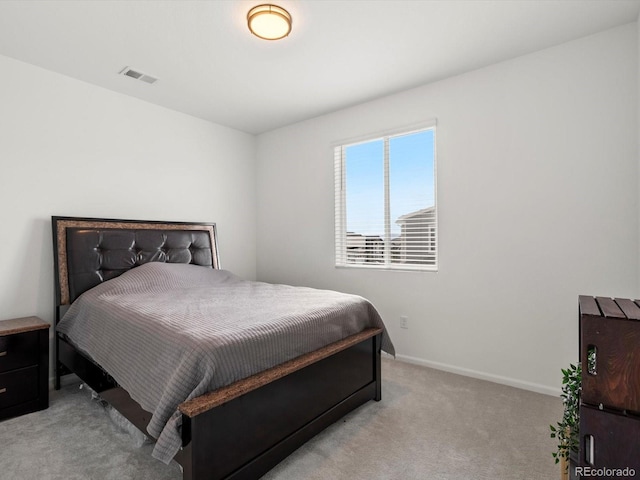 bedroom featuring visible vents, baseboards, and light carpet