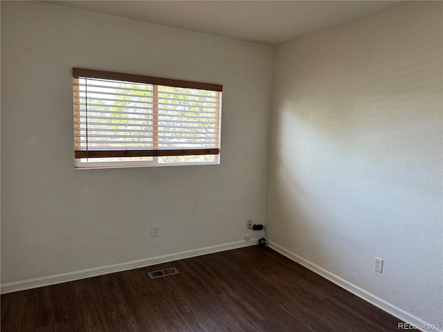 897 Mockingbird Ln, Brighton, CO 80601 - unfurnished room with dark wood-style floors, healthy amount of natural light, and baseboards