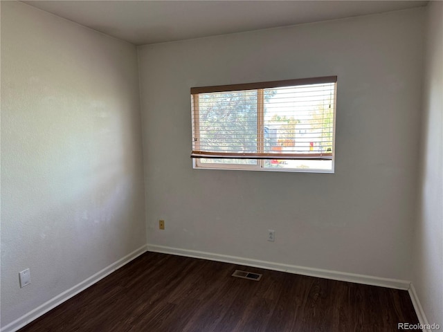 897 Mockingbird Ln, Brighton, CO 80601 - empty room with dark wood finished floors and baseboards