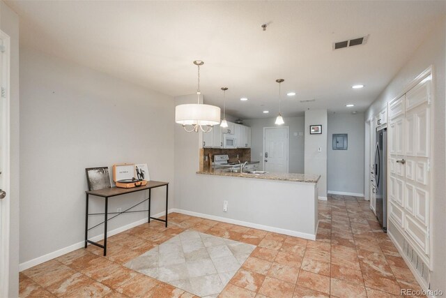 12281 E Tennessee Dr Unit 303, Aurora, CO 80012 - kitchen featuring white appliances, recessed lighting, a peninsula, white cabinetry, and pendant lighting