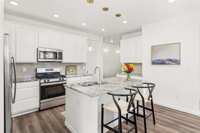 1678 Wright Aly, Erie, CO 80516 - kitchen featuring stainless steel appliances, a sink, white cabinets, dark wood finished floors, and recessed lighting
