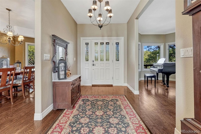 entryway with an inviting chandelier, baseboards, and dark wood-style flooring