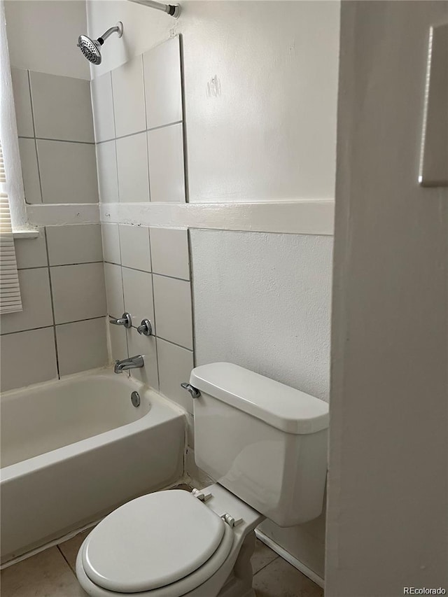 bathroom featuring tile patterned floors, tiled shower / bath combo, and toilet