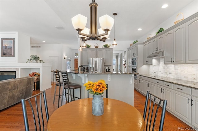 kitchen with gray cabinets, stainless steel appliances, light hardwood / wood-style floors, and a kitchen island