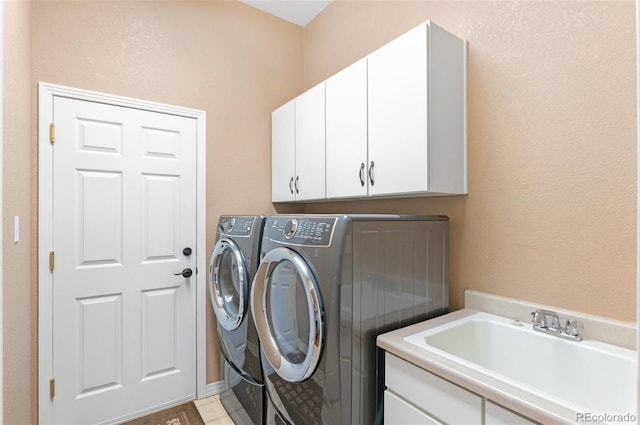 clothes washing area with independent washer and dryer, cabinets, and sink