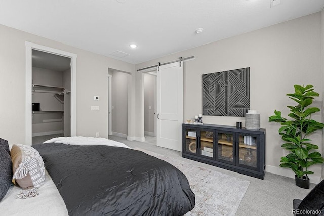 carpeted bedroom featuring a spacious closet, a barn door, recessed lighting, and baseboards