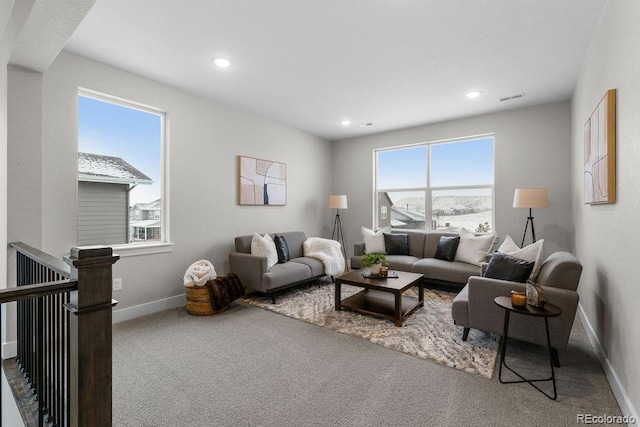 living area with carpet floors, recessed lighting, visible vents, and baseboards