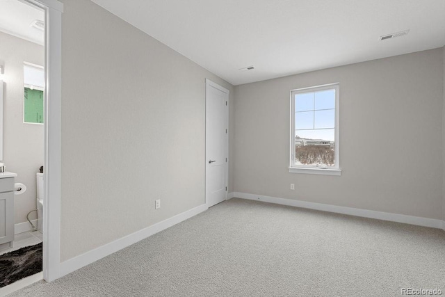 spare room with light carpet, baseboards, and visible vents