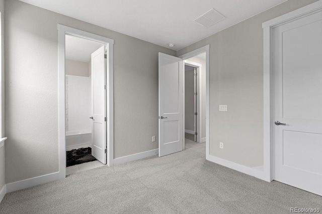 unfurnished bedroom featuring carpet, visible vents, baseboards, and ensuite bathroom