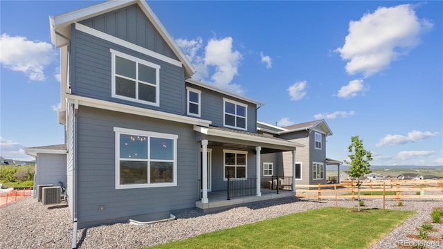 view of front of property featuring covered porch, board and batten siding, cooling unit, and fence