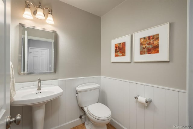 5164 E Princeton Ave, Cherry Hills Village, CO 80113 - half bathroom featuring wood finished floors, a wainscoted wall, and toilet