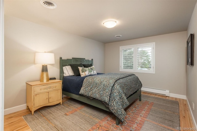 5164 E Princeton Ave, Cherry Hills Village, CO 80113 - bedroom with baseboards, baseboard heating, light wood-style flooring, and visible vents