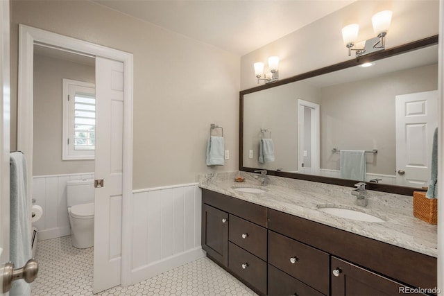 5164 E Princeton Ave, Cherry Hills Village, CO 80113 - bathroom featuring a sink, a wainscoted wall, toilet, and double vanity