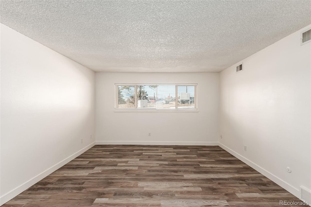 unfurnished room with dark hardwood / wood-style floors and a textured ceiling