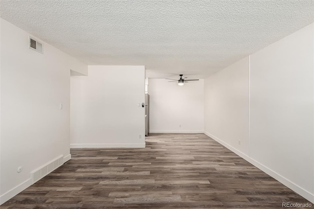 spare room with ceiling fan, a textured ceiling, and dark hardwood / wood-style flooring