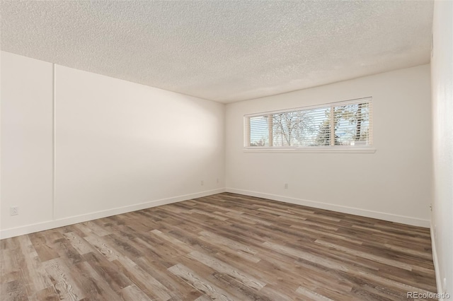 unfurnished room with wood-type flooring and a textured ceiling