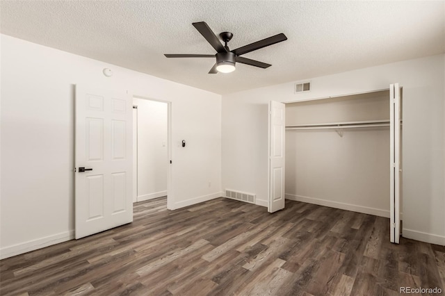 unfurnished bedroom with a closet, dark hardwood / wood-style floors, and a textured ceiling