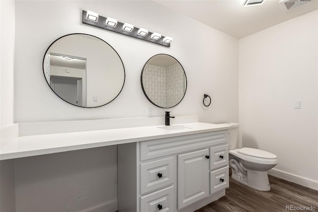 bathroom featuring vanity, hardwood / wood-style flooring, and toilet