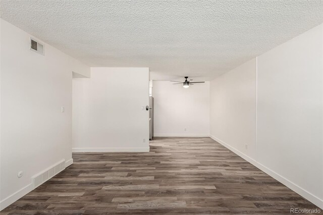 spare room featuring ceiling fan, dark hardwood / wood-style floors, and a textured ceiling