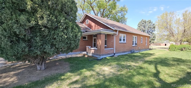 view of home's exterior with a yard and brick siding