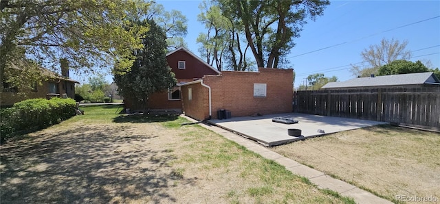 view of property exterior featuring brick siding and a patio area