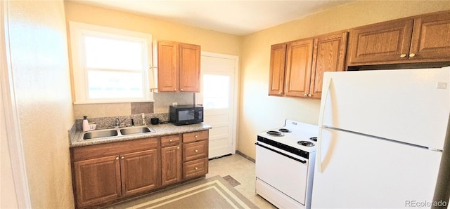 kitchen with white appliances, a sink, light countertops, brown cabinetry, and backsplash