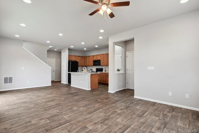 unfurnished living room with baseboards, ceiling fan, visible vents, and wood finished floors